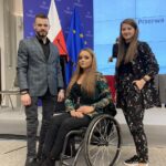 Pracownicy BON UO - Aleksandra Zagórska, Jakub Bułacz i Monika Twardawski-Karbowiak stojący na tle podium sceny, tuż przed wystąpieniem.